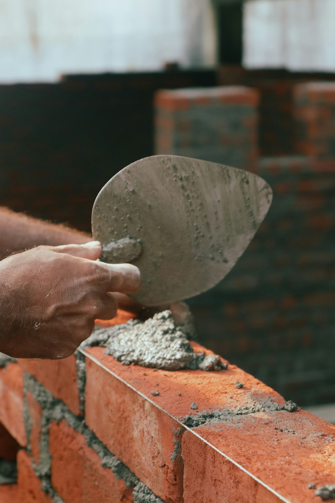 Close-up van metselwerk, troffel met specie op baksteen